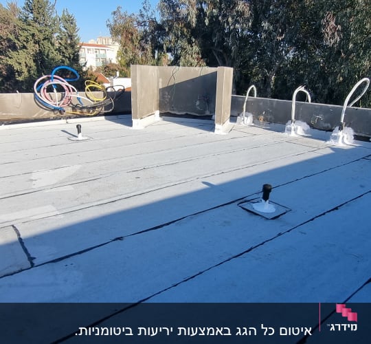 גג אטום עם יריעות ביטומניות וצינורות אטומים